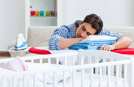 照顾新生儿的年轻爸爸照片