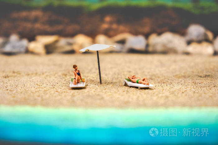 夏日背景日光浴夫妇在荒芜的沙滩上晒日光浴