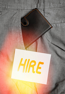 文字写作租用。雇佣某人或支付某人做一项特定工作的商业概念雇佣工资男子裤子前口袋里的小钱包靠近记号纸。
