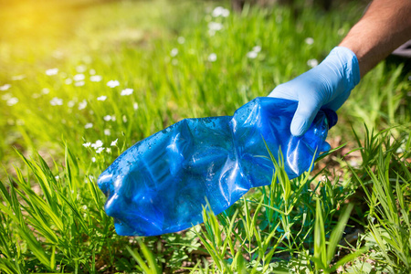 地球,人类志愿手在森林里捡垃圾,为清洁的地球,环境和生态友好照片