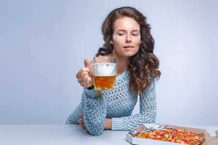 灰色背景的快乐女人，披萨和啤酒，文本空间