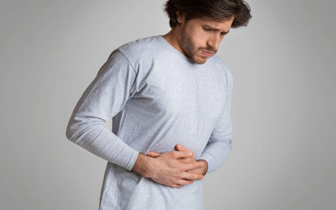 疼痛难忍手放在肚子上,疼痛难忍.食物中毒,抽筋照片