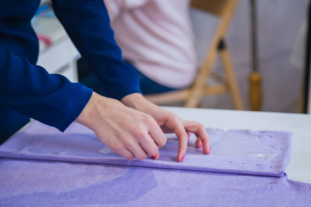 裁缝，设计师在缝纫工作室测量布料特写侧视图