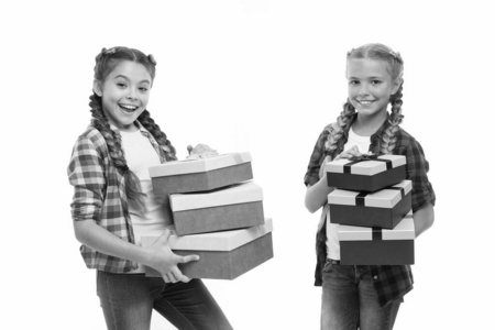 带辫子的小女孩拿着成堆的礼盒。孩子们对打开礼物的包装感到兴奋。小女孩姐妹收到生日礼物。梦想成真。最好的生日和圣诞礼物