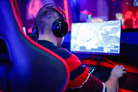 专业的网络游戏玩家工作室与个人电脑流在霓虹色模糊背景。软聚焦
