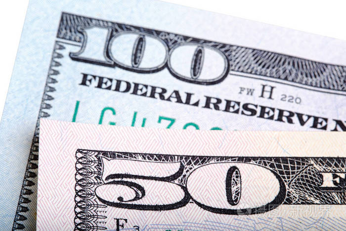 100美元和50美元的钞票钞票堆积在白色照片上