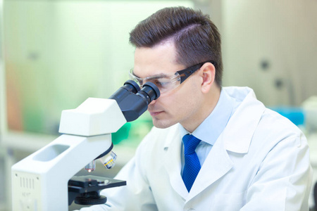 科学家在医学实验室里用显微镜进行科学研究。科维德19。冠状病毒