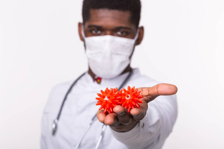 戴着无菌手套的医生拿着一个covid-19新型冠状病毒的模型,就像一场大