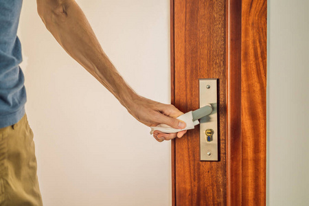 戴口罩的男子用餐巾纸开门保护感染covid-19照片