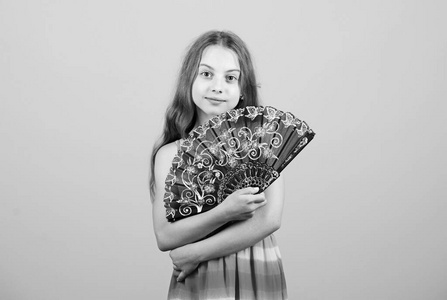 冷却和通风.挥手创造气流.小女孩挥舞着优雅的扇子.夏日酷暑.