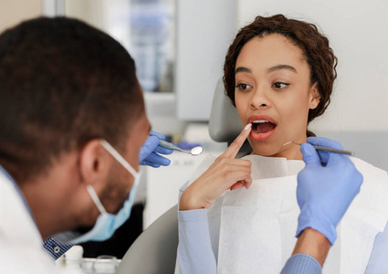 女病人坐在牙医椅上露出牙齿