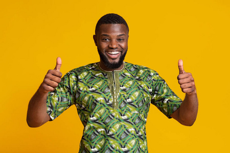 非洲绿鸠一个穿着非洲绿衬衫的快乐黑人竖起大拇指照片
