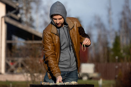 手上有烤肉串。一个男人在街上用煤烧肉