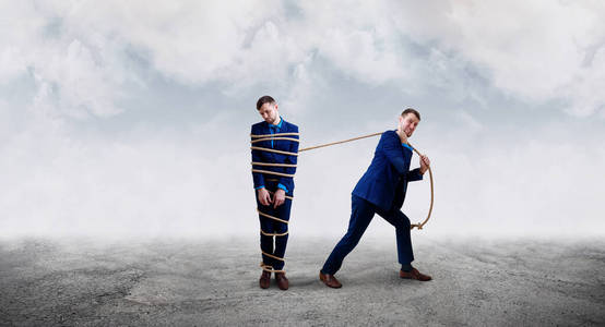 把绑起来愤怒的商人用绳子把自己绑起来.照片