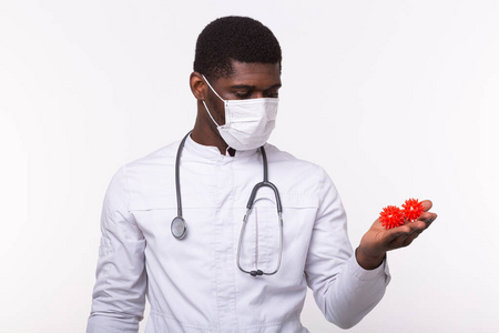 戴着无菌手套的医生拿着一个covid-19新型冠状病毒的模型,就像一场大