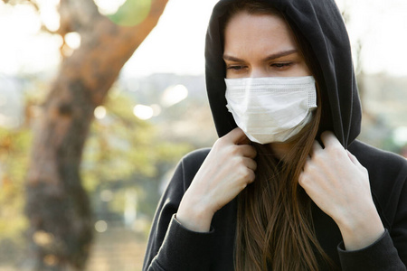 冠状病毒爆发期间戴口罩的妇女。防止病毒感染废气和工业排放