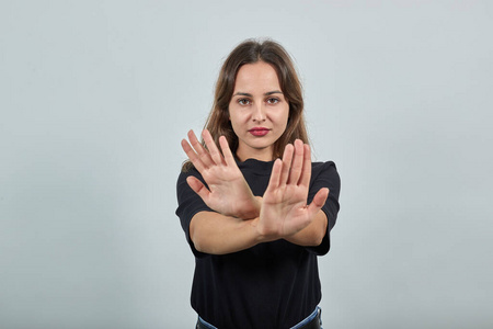 持不同意见的女孩交叉双手,象征着抗议和反对照片