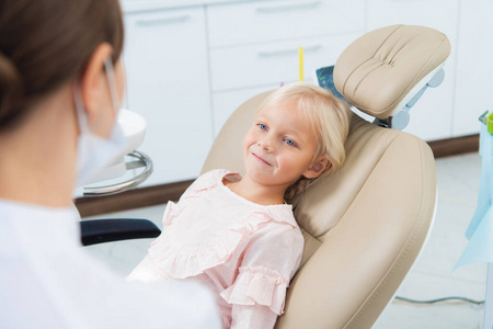 可爱的小女孩坐在牙科诊所里