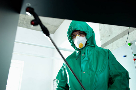 办公室家具消毒时使用化学品的男子库存照片照片