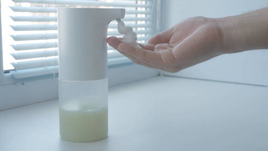 男子使用自动泡沫皂液器，洗手，关，宏，放在窗台上