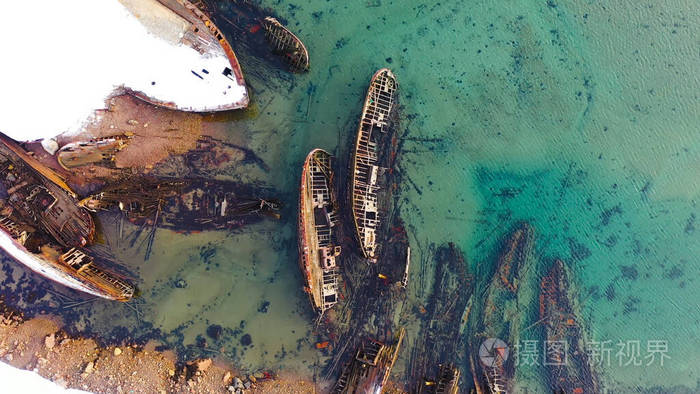 雪域海岸外碧绿海水中船只墓地的俯视图近岸沉船有绿松石色的冬季海水