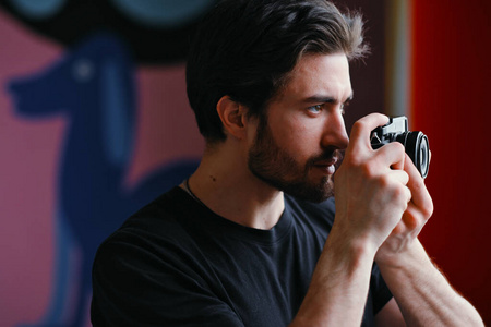 男摄影师用无镜相机拍照。