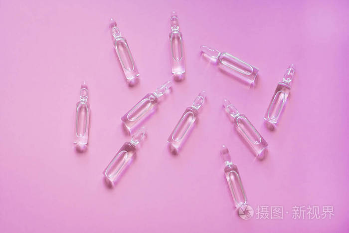 粉红色背景上有药物的安瓿药物治疗