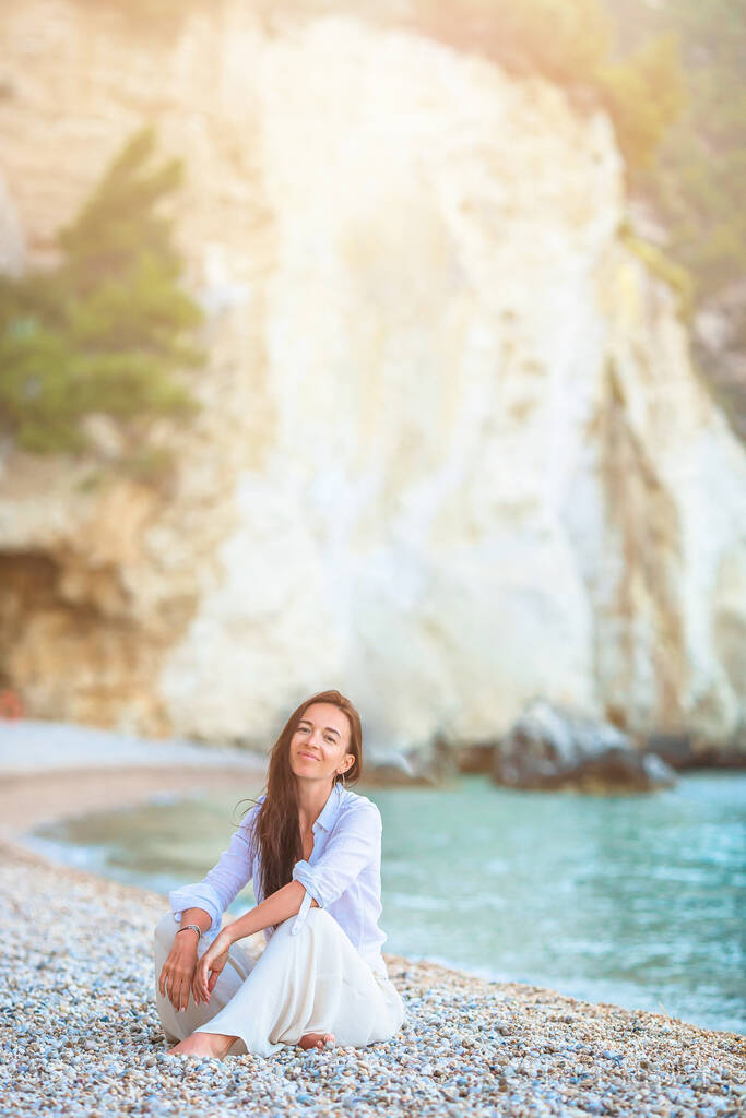 年轻美丽的女人在白色的热带海滩上。