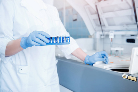 生物工程师将血浆样本安装在自动测试仪中进行dna分析,并检查对抗生素