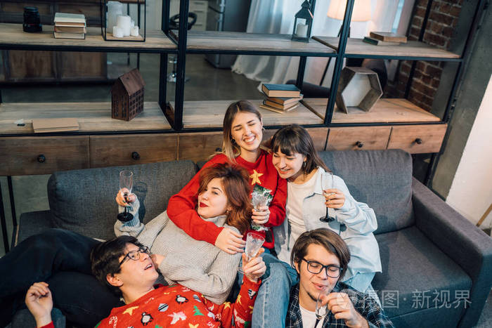 一群朋友坐在客厅的沙发上聊天