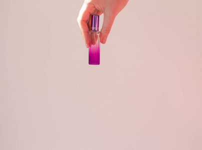  A young woman holds a bottle of perfume mockup on a white backg