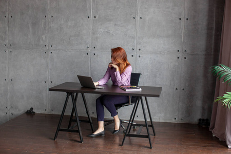 年轻的白人女性在现代办公室或在家里用笔记本电脑工作。