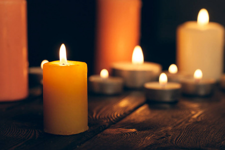 黑暗中在黑色背景上燃烧的蜡烛。纪念概念。