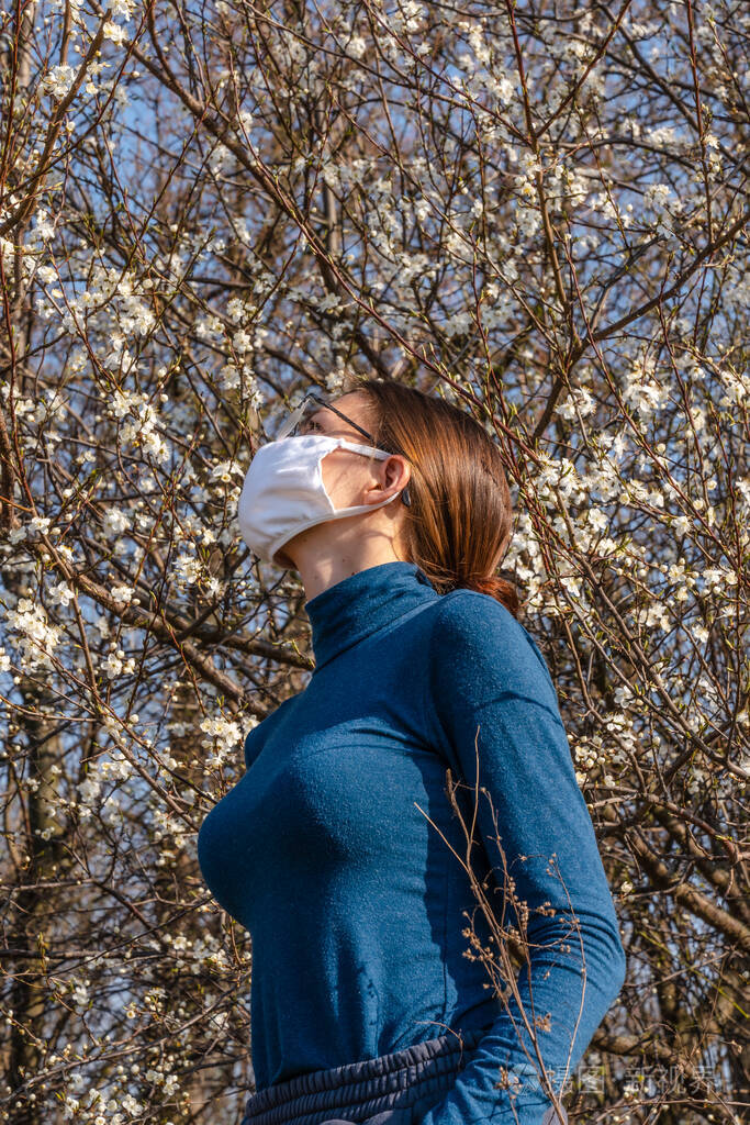 一个戴着白色口罩以防冠状病毒的年轻女孩