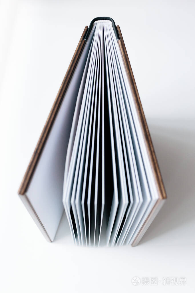 白色的背景上放着一本打开的带有木制封面的相册平躺