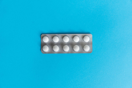 包里药片的俯视图.蓝色背景的白色药丸.