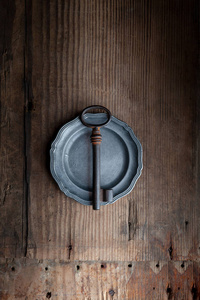  old key lies on an antique plate on a wooden background