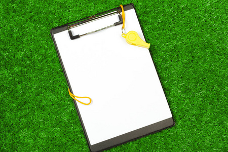 一张纸和体育器材在草地上的特写照片