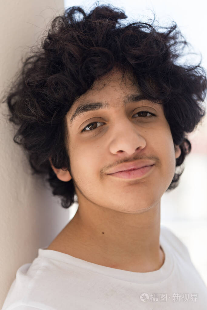 一个头发凌乱的少年男孩的头肩肖像