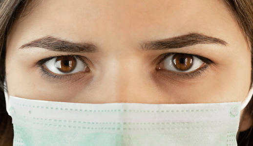 冠状病毒或covid 19面具女人大眼睛在医学面具特写肖像。