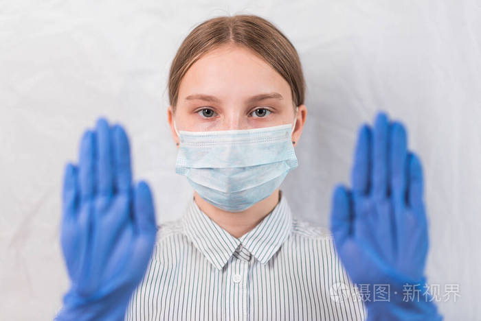 1215岁少女在医用口罩遮住脸上手势用手套放在脚上注意危险白色背景co