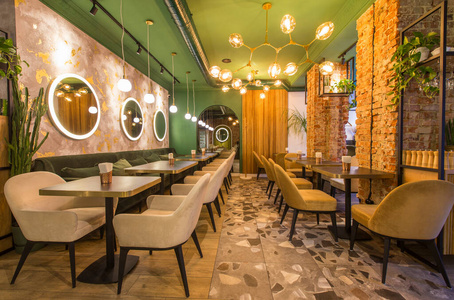 现代餐厅内部配有桌子和沙发，浅绿色墙壁