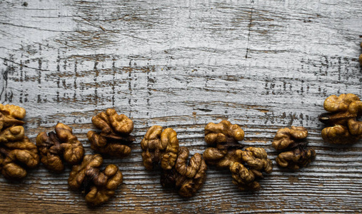 胡桃木散落在古董木桌上。核桃是一种健康的素食蛋白质营养食品。胡桃木在古朴的老木头上。复制空间。