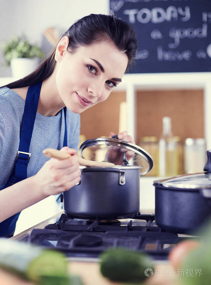 厨房里用木勺做饭的女人