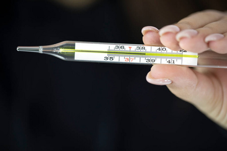 手持温度计女性手持水银温度计,显示体温为38.5度,高烧照片