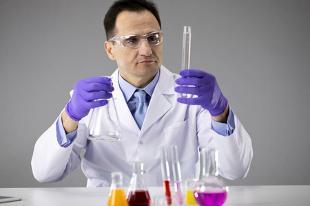戴着护目镜的聪明科学家在化学实验室用反应管工作
