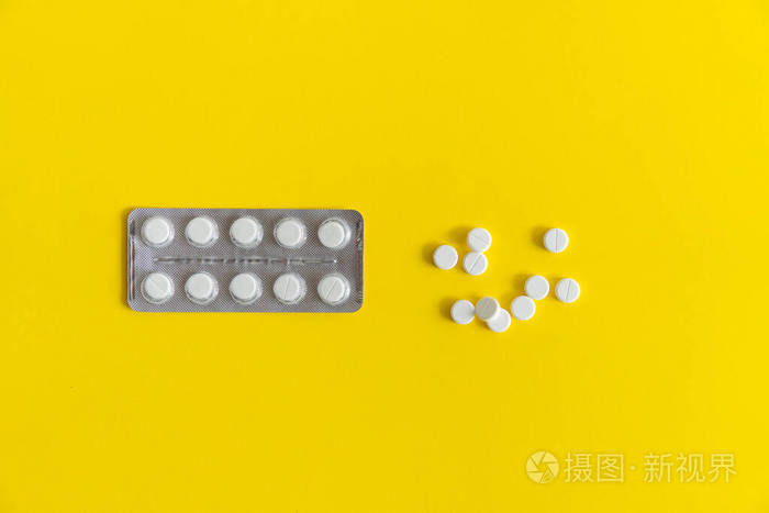 包里药片的俯视图。黄色背景的白色药丸。药品，药物，止痛药，片剂，药物，抗生素，维生素，治疗，胶囊，剂量。药房主题。
