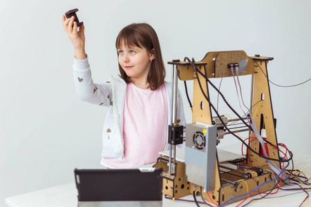 儿童建筑师使用三维打印机。女学生，技术和学习观念。