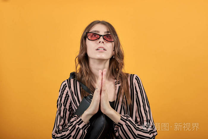 怀着希望的女孩向上帝祈祷双手合十抬起头来