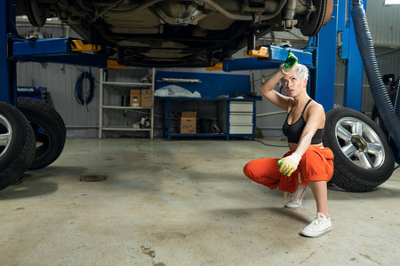 一个性感的年轻女人在汽车服务中心修车